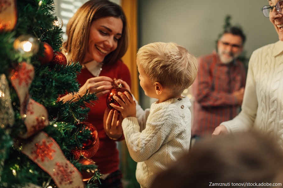 Familie beim Schmücken des Weihnachtsbaumes